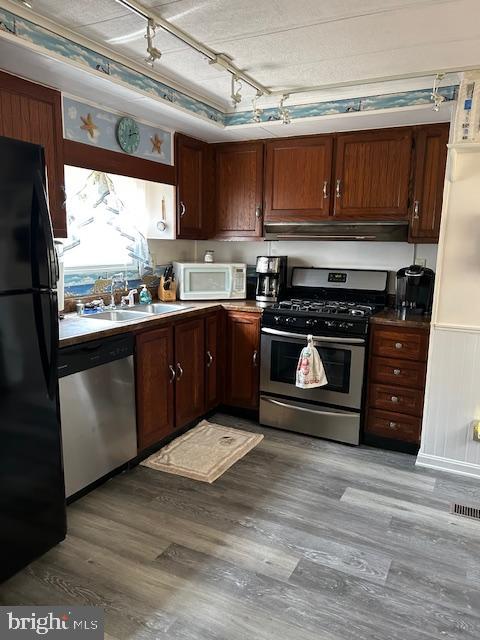 33998 Sunflower Road, Unit 19190 Lewes, DE 19958 - Photo 21 of 26 a kitchen with stainless steel appliances granite countertop a stove a sink and a microwave