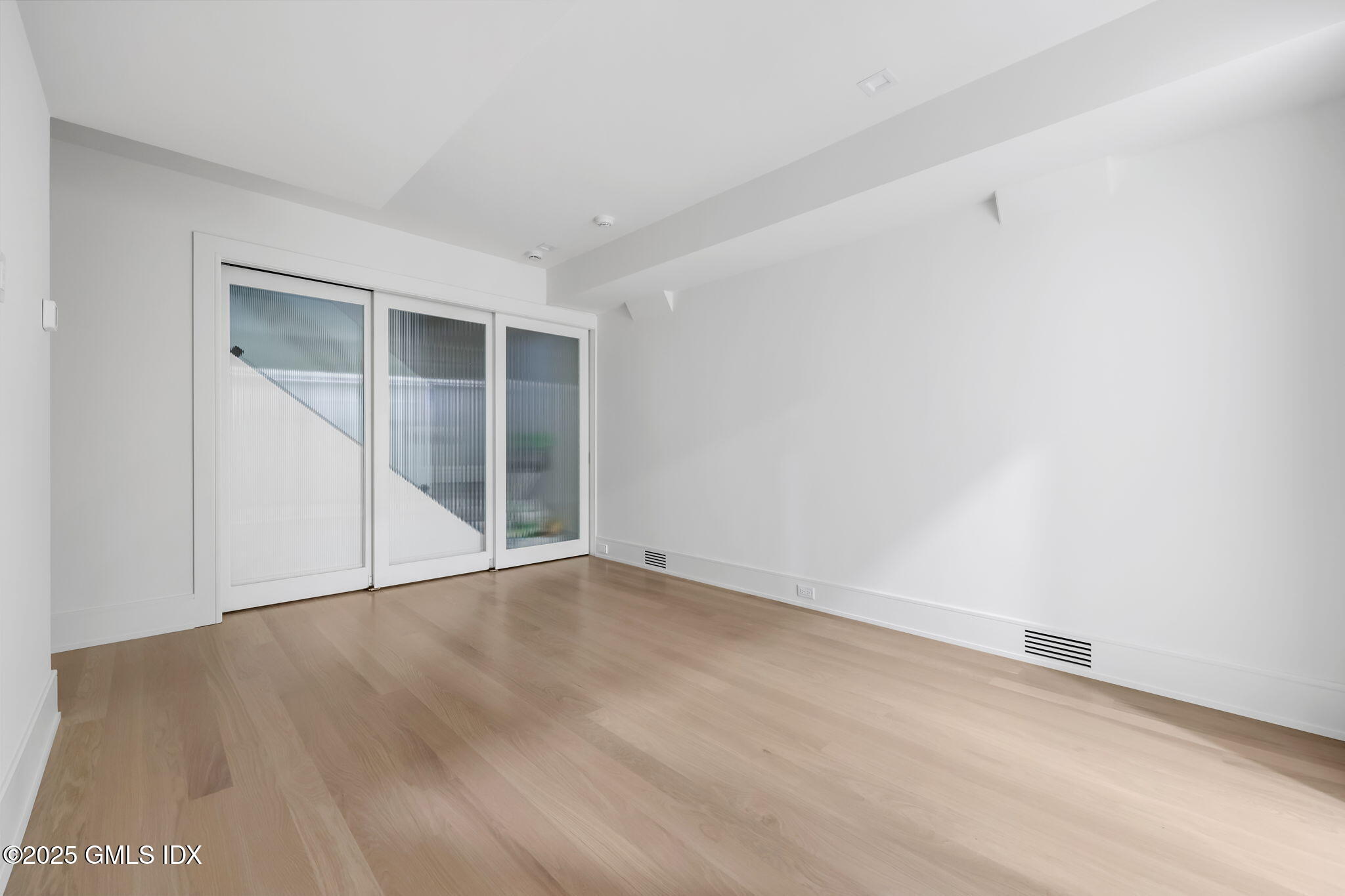 187 Field Point Road, Unit A Greenwich, CT 06830 - Photo 25 of 32 an empty room with wooden floor and windows