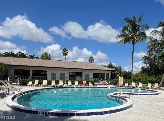 a view of house with swimming pool and outdoor seating