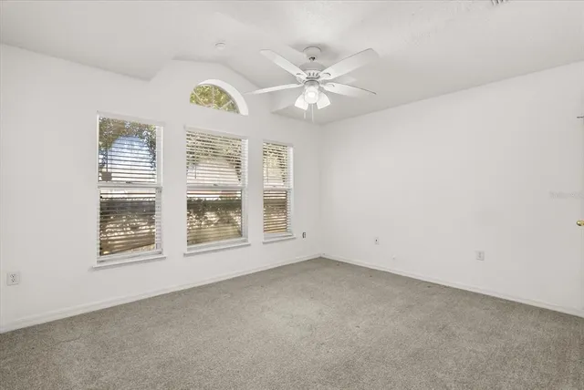 an empty room with a window and a fan
