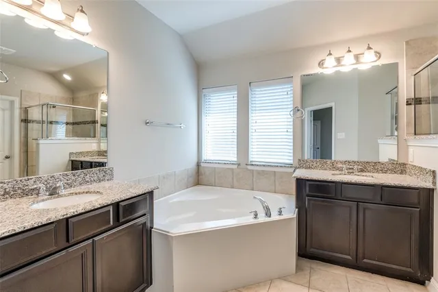 a spacious bathroom with a granite countertop sink mirror and a bath tub