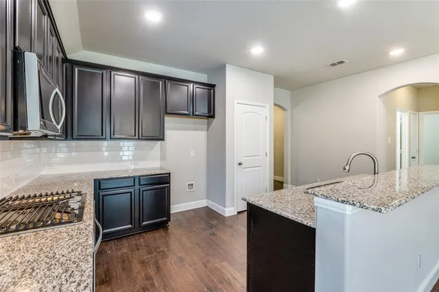 a kitchen with granite countertop stainless steel appliances and wooden cabinets