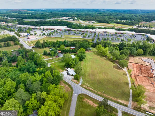 an aerial view of a residential houses with outdoor space and trees