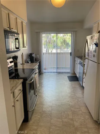 a kitchen that has a sink a stove and a refrigerator