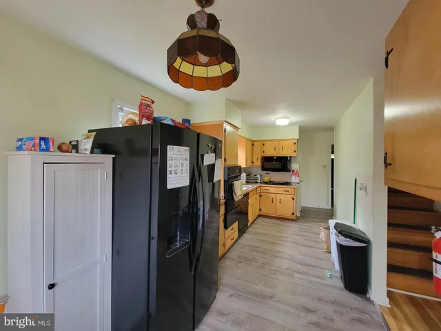 a kitchen with stainless steel appliances kitchen island granite countertop a refrigerator and a stove top oven