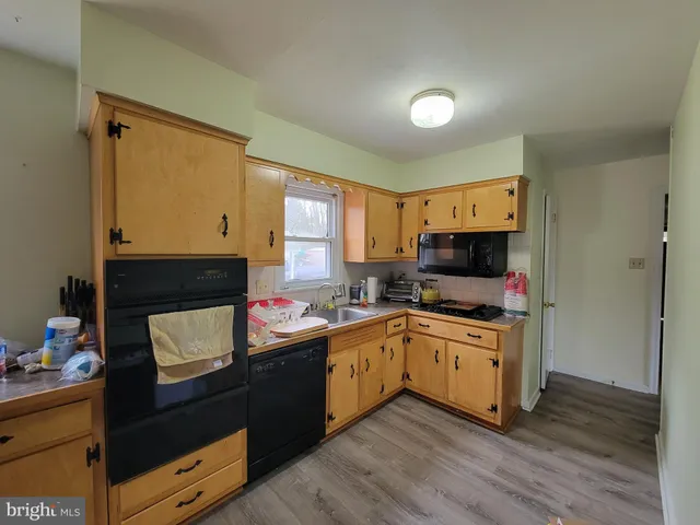 a kitchen with granite countertop a sink cabinets and wooden floor