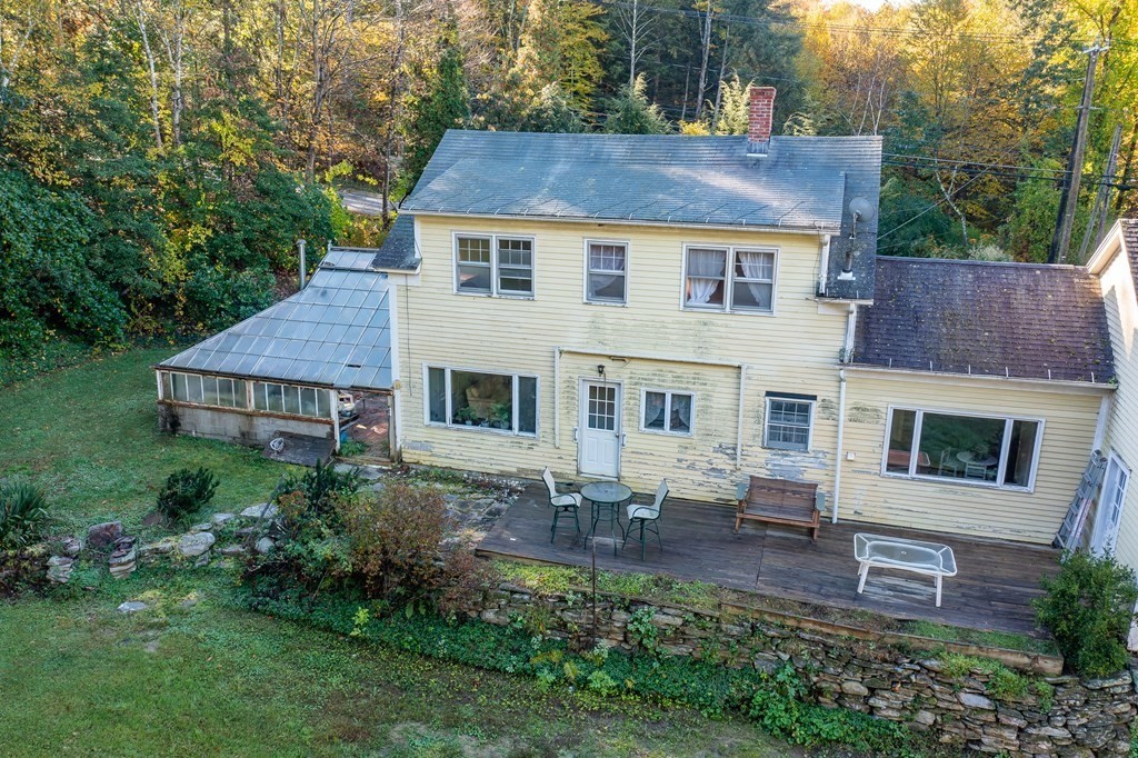 76 Amherst Road Pelham, MA 01002 - Photo 8 of 42 a aerial view of a house with table and chairs next to a yard