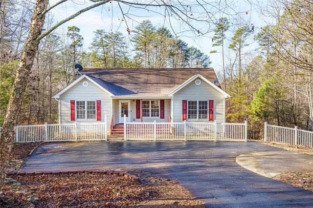 a front view of house with wooden deck and a yard