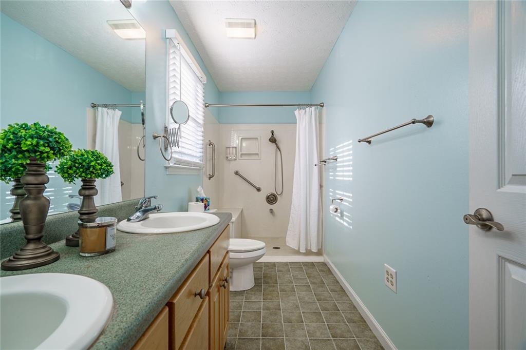 450 High Ridge Lane Dahlonega, GA 30533 - Photo 17 of 39 a bathroom with sink a mirror a toilet and shower