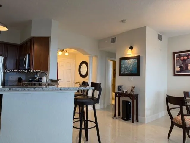 a living room with furniture a flat screen tv and kitchen view