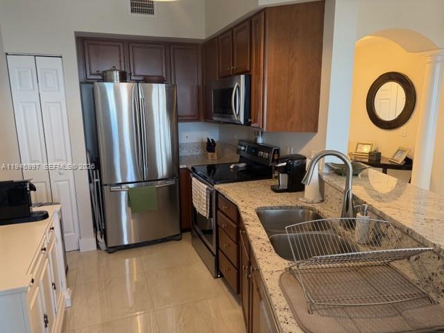 9021 Southwest 94th Street, Unit 708 Miami, FL 33176 - Photo 4 of 11 a kitchen with stainless steel appliances granite countertop a sink a refrigerator and a stove