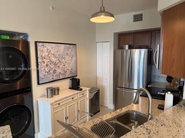 a kitchen with stainless steel appliances granite countertop a refrigerator sink and stove
