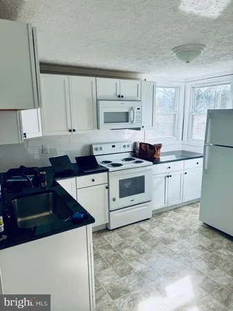 a kitchen with a stove sink and cabinets