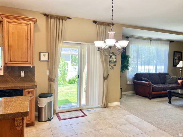 369 Culross Circle Tooele, UT 84074 - Photo 14 of 54 Open-concept living area featuring a tile floor, wood cabinetry, built-in dishwasher, and a chandelier