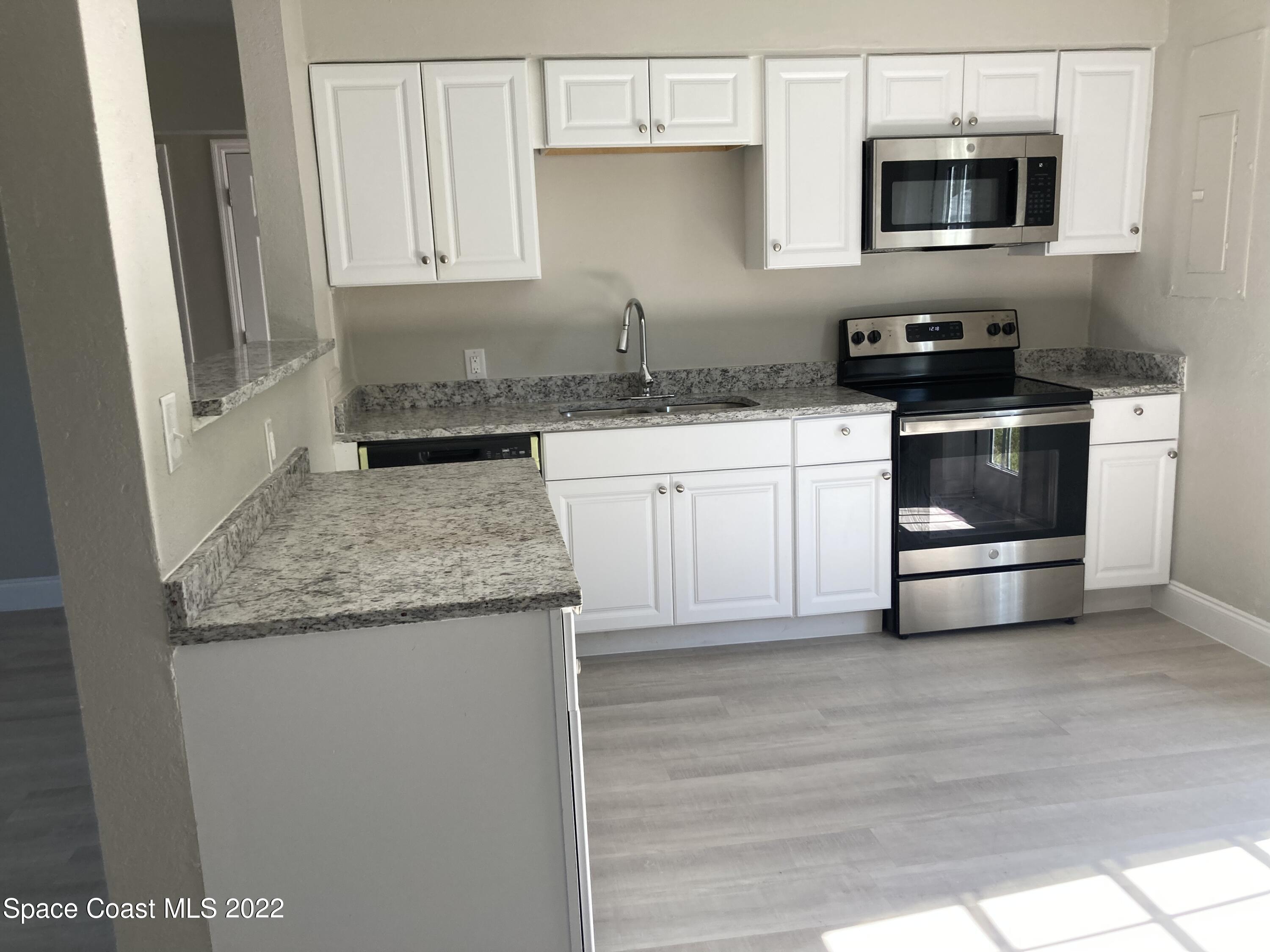 1051 Mitchell Street Cocoa, FL 32922 - Photo 7 of 21 a kitchen with granite countertop a sink and a stove top oven