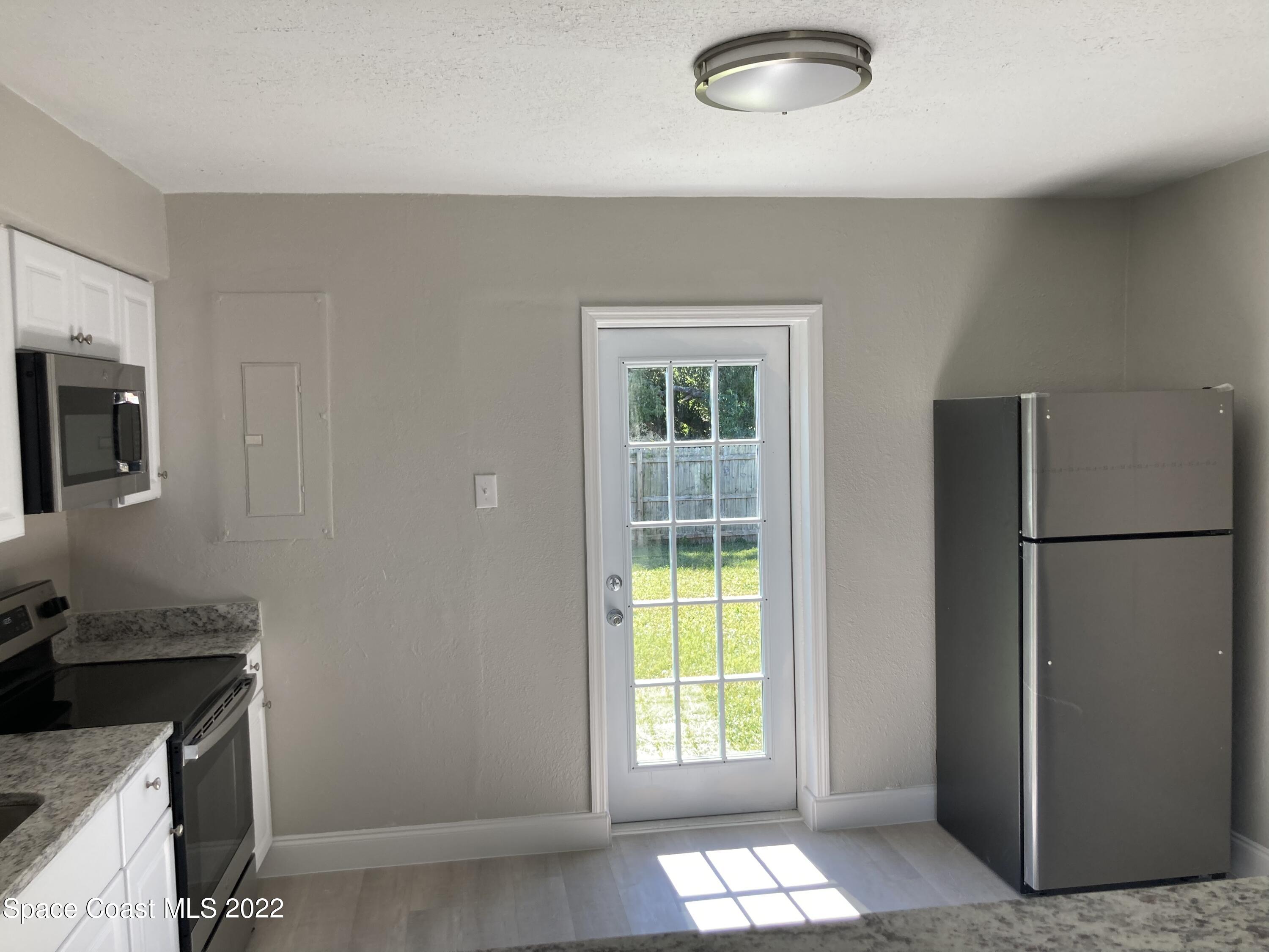 1051 Mitchell Street Cocoa, FL 32922 - Photo 9 of 21 a kitchen with a refrigerator and window