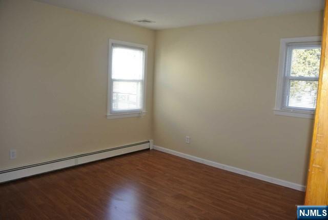 164 Scoles Avenue, Unit 2 Clifton, NJ 07012 - Photo 15 of 16 an empty room with wooden floor and windows