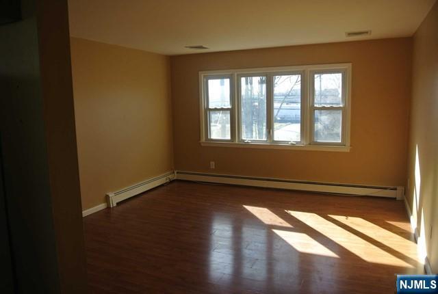 164 Scoles Avenue, Unit 2 Clifton, NJ 07012 - Photo 5 of 16 a view of an empty room with wooden floor and a window
