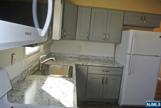 164 Scoles Avenue, Unit 2 Clifton, NJ 07012 - Photo 8 of 16 a kitchen with a sink a refrigerator and cabinets