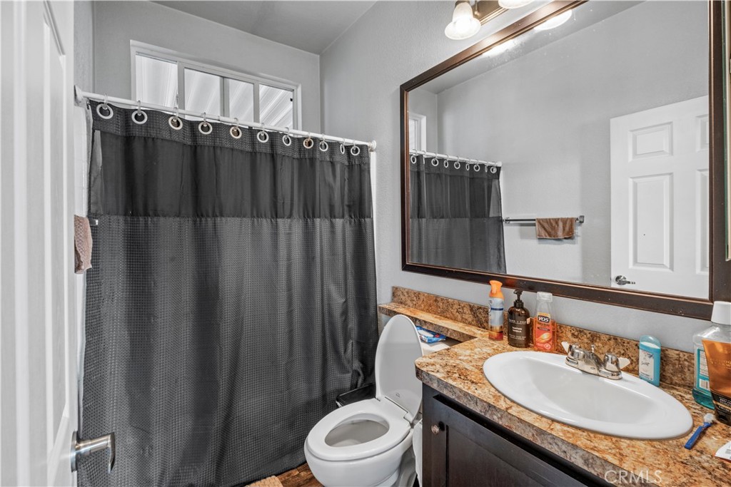 2139 East 4th Street, Unit 84 Ontario, CA 91764 - Photo 13 of 25 a bathroom with a granite countertop sink vanity mirror and toilet