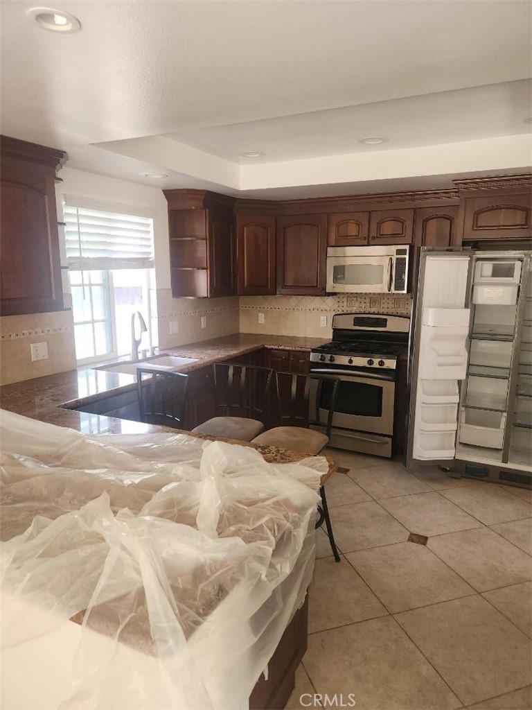 1111 Valley Circle Costa Mesa, CA 92627 - Photo 3 of 7 a kitchen with stainless steel appliances kitchen island granite countertop a stove and cabinets