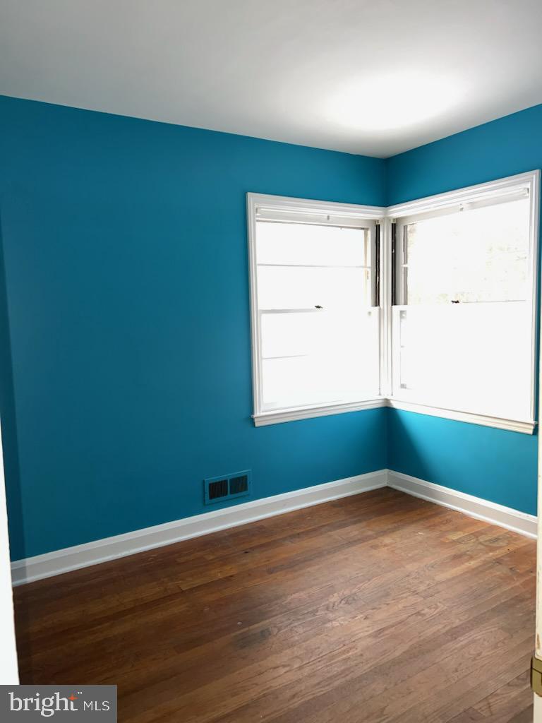 23 Kingsley Road Owings Mills, MD 21117 - Photo 5 of 9 an empty room with wooden floor and windows