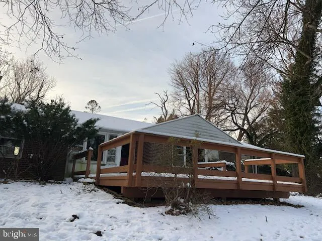 a front view of a house with a yard covered with snow in the yard
