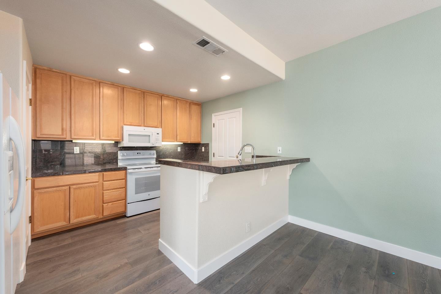 72 Cannery Circle Campbell, CA 95008 - Photo 8 of 20 a kitchen with granite countertop white cabinets and white appliances