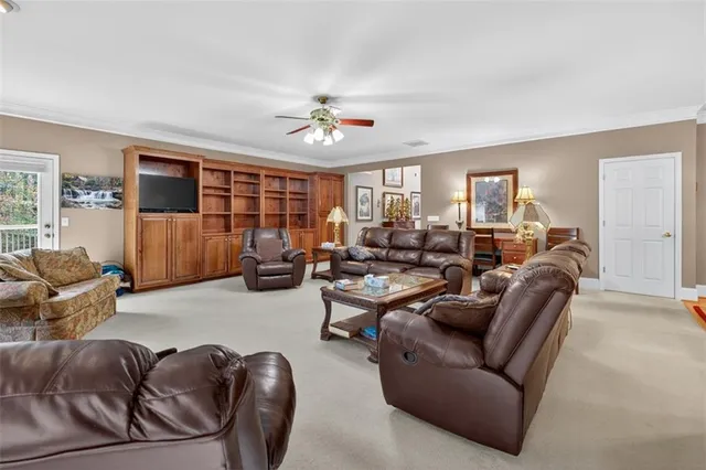 a kitchen with stainless steel appliances granite countertop wooden cabinets a sink a stove a dining table and chairs