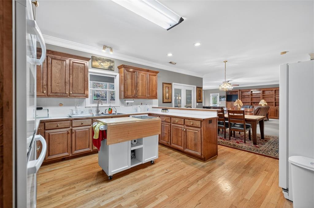 3357 Rising Fawn Trail Suwanee, GA 30024 - Photo 17 of 93 a kitchen with stainless steel appliances granite countertop wooden cabinets a sink a stove a dining table and chairs