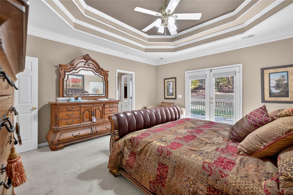 3357 Rising Fawn Trail Suwanee, GA 30024 - Photo 23 of 93 a bedroom with a bed a dresser and flat screen tv