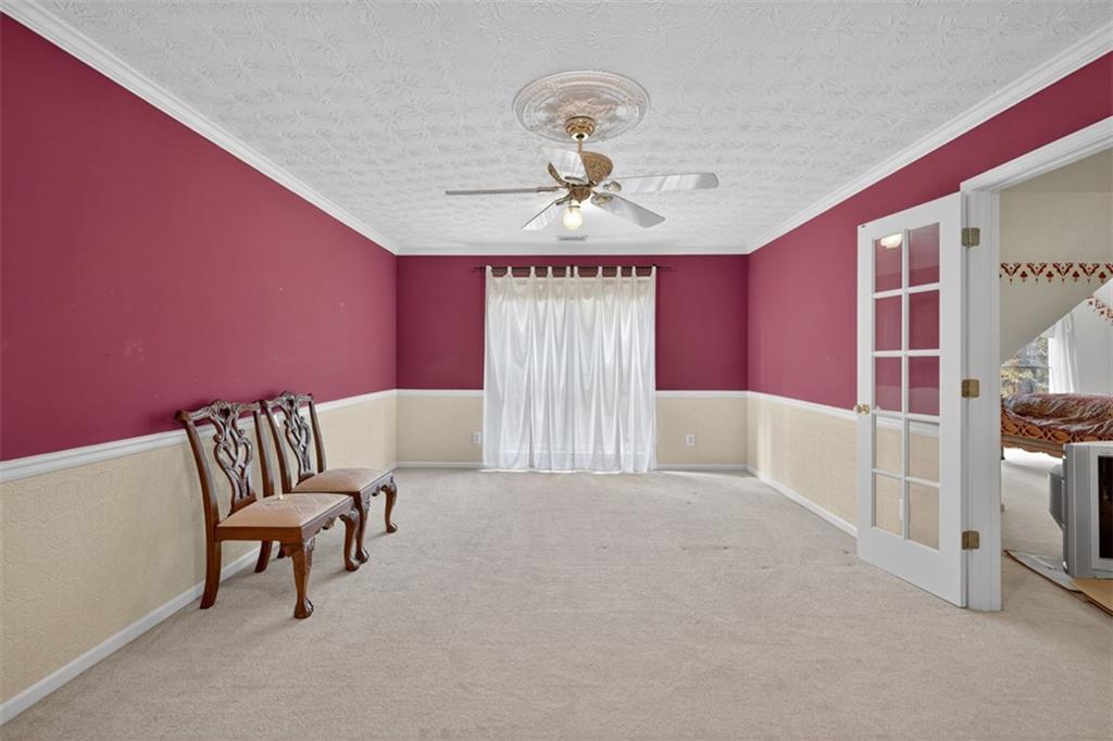 3357 Rising Fawn Trail Suwanee, GA 30024 - Photo 41 of 93 a spacious bedroom with a bed and a chandelier