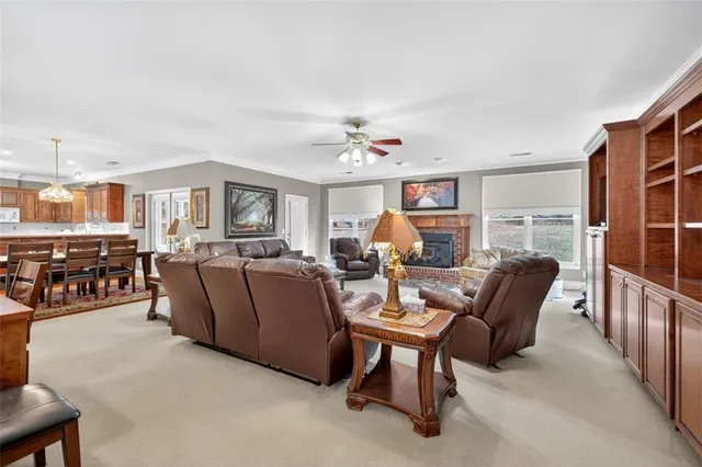a living room with furniture a ceiling fan and a window