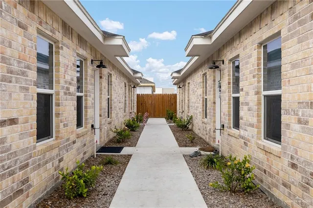 a pathway of a house with a yard