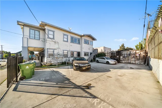 a front view of a building with cars parked