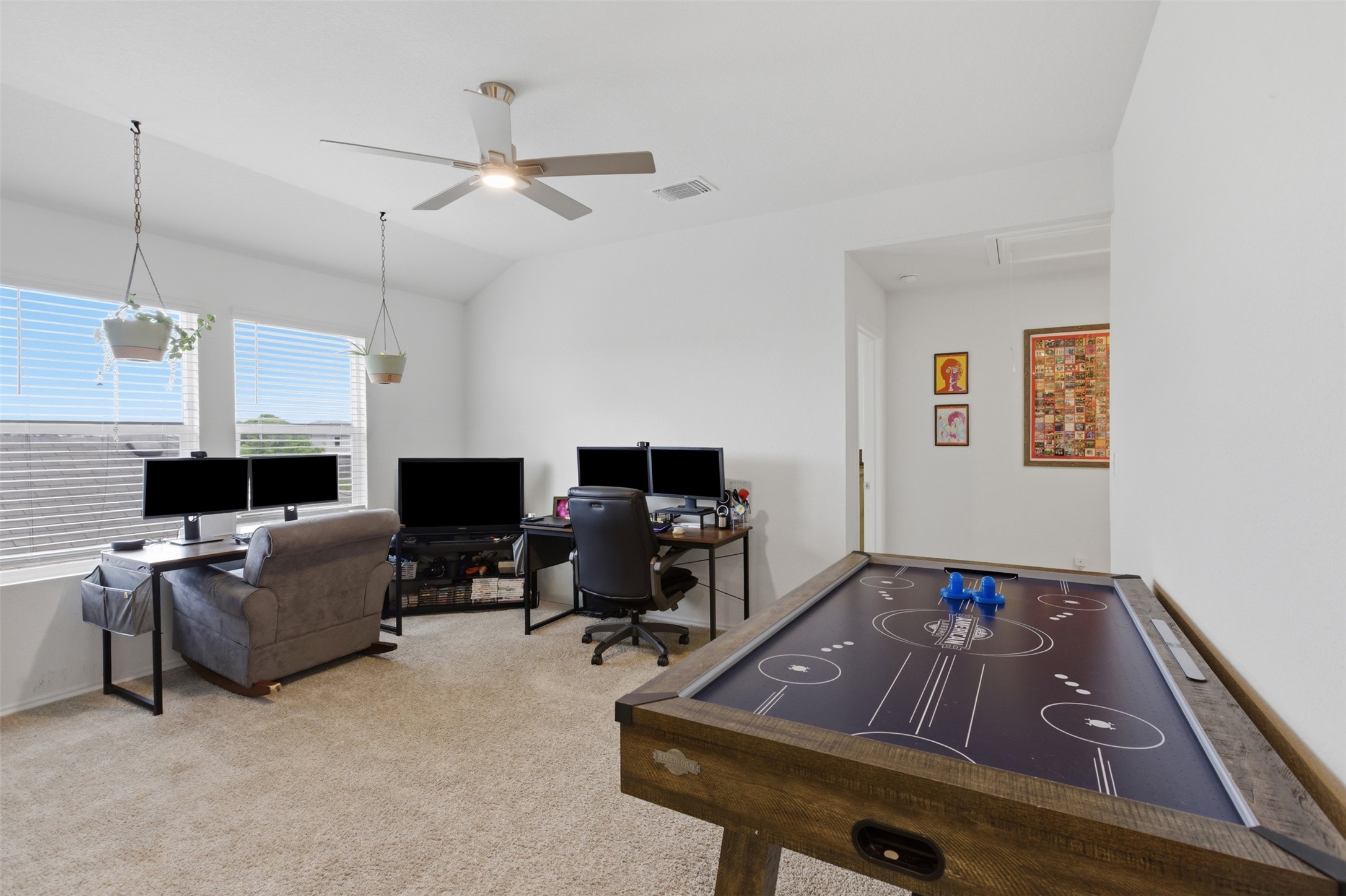 19017 Romano Drive Elgin, TX 78621 - Photo 19 of 33 Carpeted bonus room featuring vaulted ceilings, a contemporary ceiling fan, and multiple windows with horizontal blinds