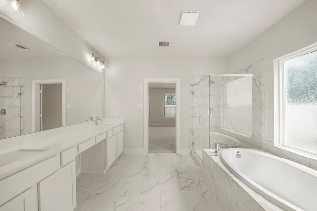 a spacious bathroom with a bathtub shower and a sink