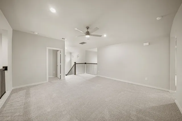 an empty room with a ceiling fan and a window