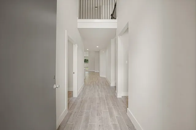 a view of a hallway with wooden floor and staircase
