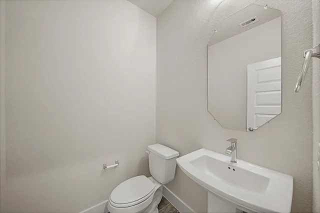 a bathroom with a toilet a sink and mirror