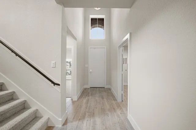a view of a hallway with wooden floor and entryway