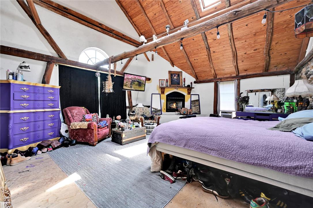 101 Conrad Road Fleetwood, PA 19522 - Photo 11 of 42 Exposed beams and wood ceilings create a distinctive character in this spacious sleeping area, featuring a warm fireplace for cozy evenings.