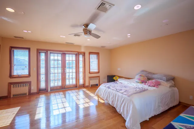 a bedroom with a large bed and wooden floor
