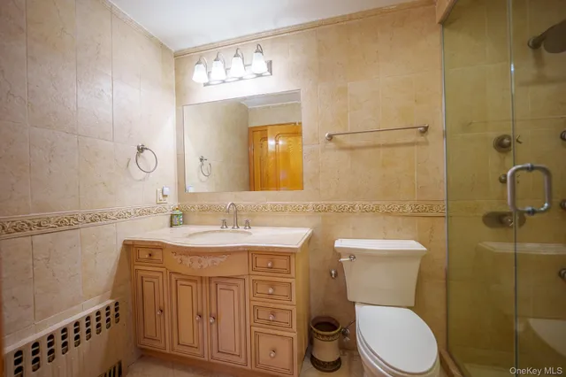 a bathroom with a toilet a sink a mirror and a shower