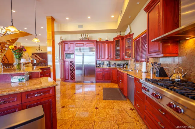 a kitchen with stainless steel appliances granite countertop a stove a sink and a wooden cabinets