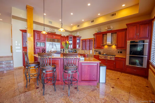 a kitchen with stainless steel appliances kitchen island granite countertop a table chairs and a refrigerator