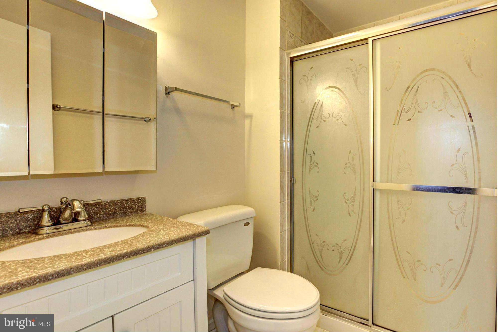 8933 Centerway Road Gaithersburg, MD 20879 - Photo 19 of 29 a bathroom with a granite countertop sink toilet and shower