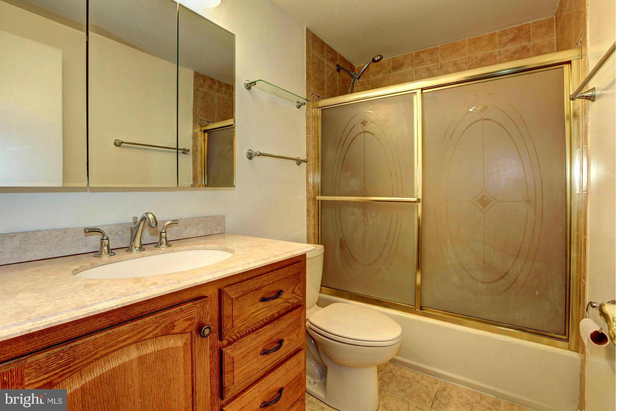 8933 Centerway Road Gaithersburg, MD 20879 - Photo 20 of 29 a bathroom with a granite countertop sink toilet and shower
