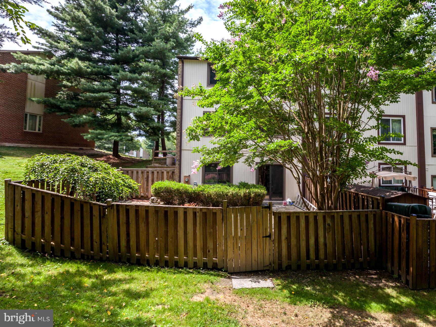 8933 Centerway Road Gaithersburg, MD 20879 - Photo 3 of 29 a view of a backyard with a large tree and wooden fence