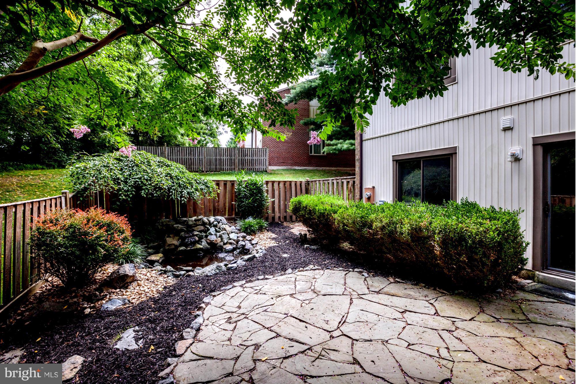 8933 Centerway Road Gaithersburg, MD 20879 - Photo 8 of 29 a view of a backyard with potted plants and large tree